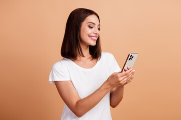 Fototapeta premium Young hispanic brunette woman smiling at her phone in white tshirt casual lifestyle portrait