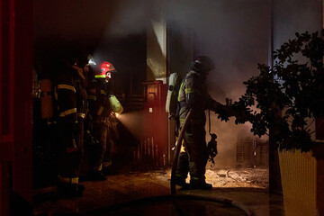 Obraz premium fire brigade extinguishes a burning building at night