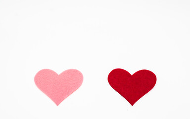 Two felt heart shapes in pink and red colors isolated on a white background. Minimal romantic composition symbolizing love, relationship, balance, and contrast. Ideal for Valentine&rsquo;s Day designs.