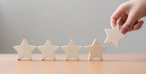 A hand places a wooden star onto a row of stars, symbolizing achievement, rating, or progression in a creative and minimalist setup.