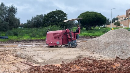 The excavator works to clear the soil and move it out of the excavation at the construction site. 