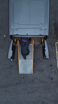 Roadie loading flight case into van aerial view