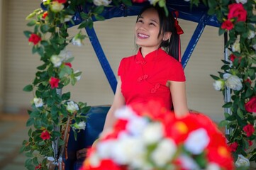 Young Woman in Red Attire Surrounded by Flowers for New Year Celebration