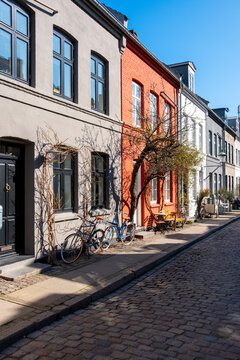 Empty street cobblestone leads past bicycle and colorful architecture facade as sunlight shapes urban copenhagen denmark atmosphere