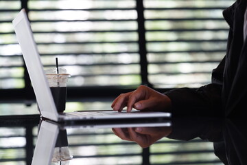 Close-up of hands typing on a laptop keyboard, remote work or digital nomad lifestyle.
