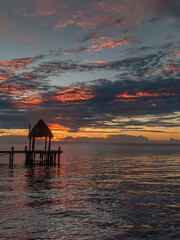 Fototapeta premium A stunning and colorful sunrise on a wooden pier on the beach in Cancun, Mexico