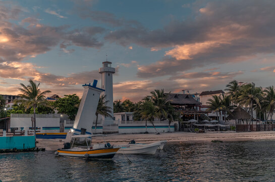 The Leaning Lighthouse of Puerto Morelos on the beach during a colorful sunset