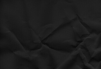 High-resolution black crumpled paper texture with deep folds and subtle shadows, full frame background.