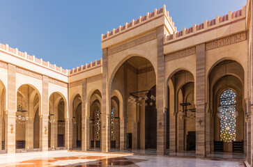 Obraz premium Sunlit Pointed Arches and Decorative Islamic Calligraphy at Al Fateh Grand Mosque Exterior in Bahrain
