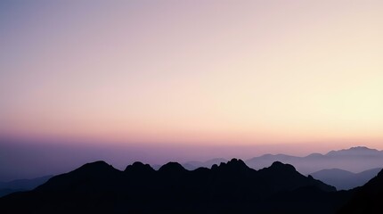 Obraz premium Mountain silhouettes at dawn with purple pink gradient sky and layered peaks creating peaceful atmospheric landscape for meditation and nature themes.