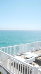 Fototapeta premium Serene ocean view from white wooden deck with lounge chairs overlooking turquoise water and clear blue sky for vacation relaxation and coastal living.
