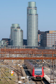 Modern urban skyline architecture with skyscrapers above railway train transport in Copenhagen Denmark showing infrastructure and mobility
