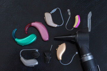 Hearing Aids and Otoscope on a Dark Surface