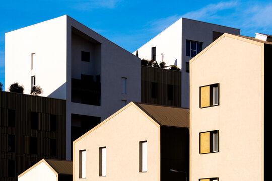 Modern residential apartment facade architecture with geometric white rooftop forms for urban real estate development in Montpellier France