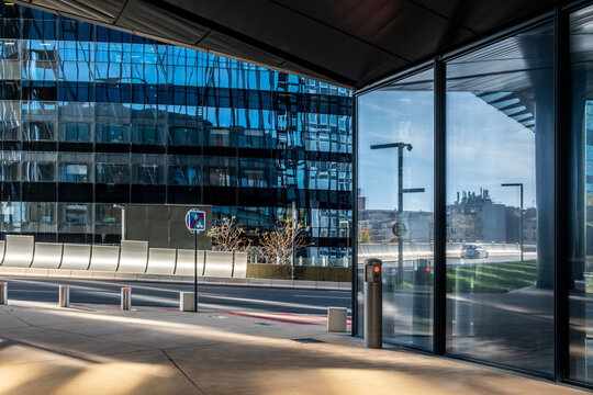 Modern corporate office architecture shows glass reflection along quiet street in Paris La Defense creating urban business scene with clean lines
