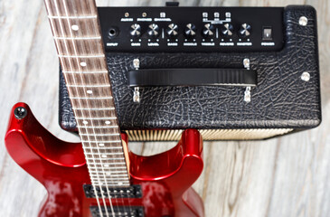 Fototapeta premium Red electric guitar resting on a black amplifier
