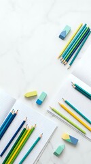 Fototapeta premium Colorful pencils and erasers arranged on white background with grid paper for creative projects and educational activities.