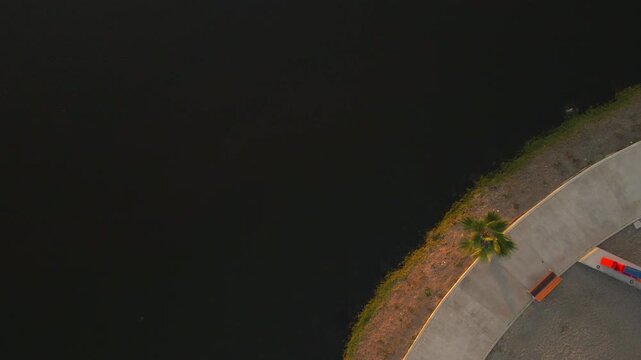 Aerial view of the central park lake in Mazatlan at sunset, peaceful water reflections, 4k.