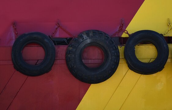 Car tires used as fenders at the bow of a traditional Greek wooden fishing boat at the port of Eleusis in Attica, Greece