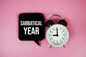 Sabbatical Year text on speech bubble with alarm clock on pink background