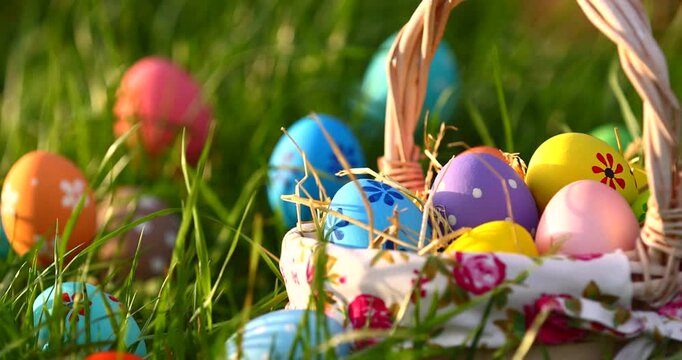 Easter basket with colorful eggs on green grass background