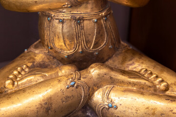 Golden Buddha statue detail with turquoise stones