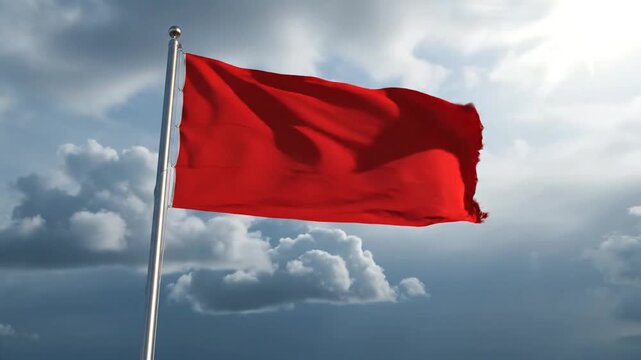 Red flag waving against cloudy sky.