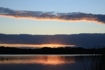Obraz premium Colorful sunset reflection on quiet lake at dusk 