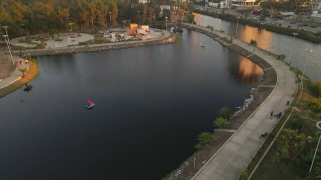 Aerial view of the central park lake in Mazatlan at sunset, peaceful water reflections, 4k.