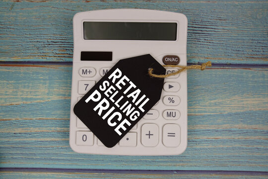 Price tag with "RETAIL SELLING PRICE" on calculator on a rustic blue wooden surface