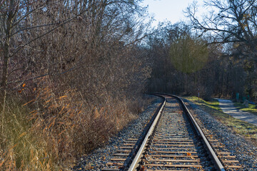 Obraz premium Empty railway track curving through winter forest landscape