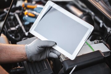 Fototapeta premium Mechanic uses a digital table to record error engine checks