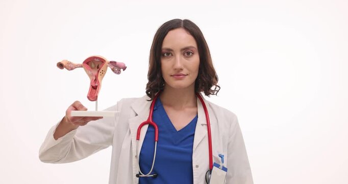Woman gynecologist holds uterus model and blister of pills. Doctor explains reproductive health describing hormonal treatment preventing pain