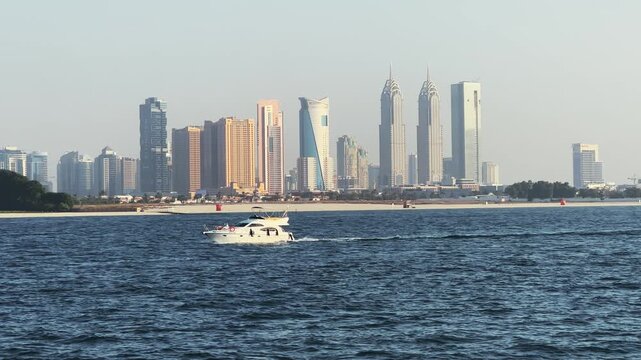 Luxury yacht motorboat sail on calm waters with Dubai Marina Skyline and skyscraper buildings in background, no logos