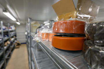 Spare plastic wheels for a forklift lying on a warehouse shelf.