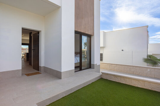 Modern home entrance with artificial grass and sliding bedroom window