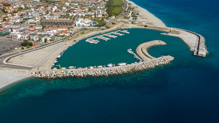 Aerial view of the Catanzaro Lido port, located on the Ionian coast of Calabria, Italy. Many small boats anchored in the clean, blue marina. It is a sunny summer morning. © Stefano Tammaro