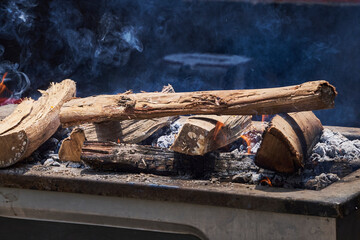 Wood logs burning during an outdoor barbecue