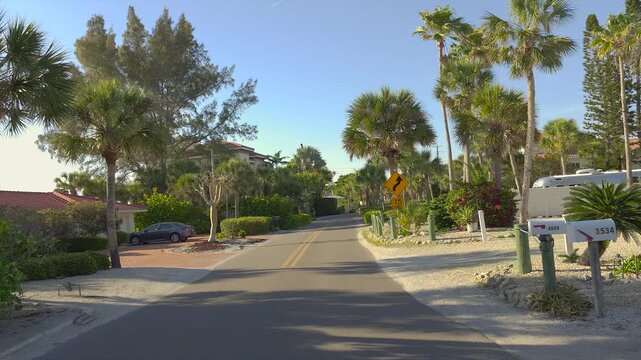 Driving on scenic road in sunny Florida. Casey Key coastal residential community picturesque streets.
