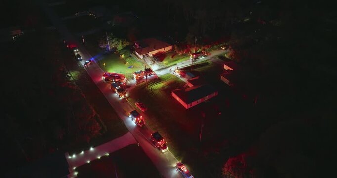 First responders arrived at fire alarm call ready to extinguish fire of burning house at night. Emergency service personnel responding to potential fire hazard at Florida home.