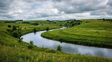 A serene river meandering through lush green hills under a cloudy sky