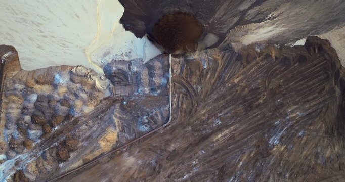 Industrial pipe spraying mixture of water and sediment at mining area, part of phosphate extraction operation in Florida.