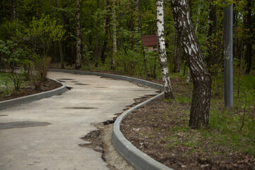Obraz premium Repair of the road in the park. Installation of curbs on the road. Road condition during repairs.