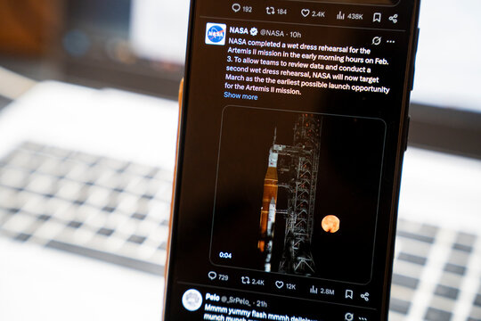 Warsaw, Poland - Feb 3, 2026: A close-up of a smartphone displaying a NASA tweet about the Artemis II mission and moon landing preparations.