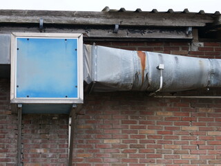 Parts of an old ventilation and heating system on a brick wall