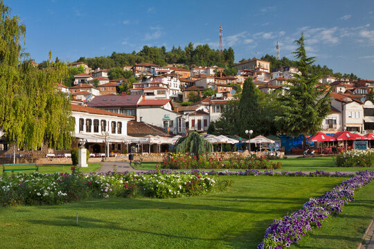 Flower promenade in the old city of Ohrid among white houses under red tile roofs climbing steps uphill. Ohrid, North Macedonia