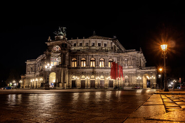 Fototapeta premium Semperoper Dresden bei Nacht mit Spiegelungen auf dem Theaterplatz