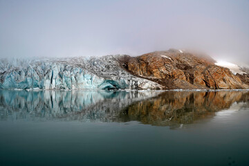 View of the waterfront infrastructure in Tasiilaq, Greenland. The clip shows the port area with shipping containers, fishing boats, and local housing, highlighting life in a remote Arctic community 