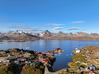 View of the waterfront infrastructure in Tasiilaq, Greenland. The clip shows the port area with shipping containers, fishing boats, and local housing, highlighting life in a remote Arctic community 