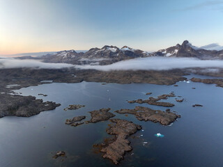 View of the waterfront infrastructure in Tasiilaq, Greenland. The clip shows the port area with shipping containers, fishing boats, and local housing, highlighting life in a remote Arctic community 